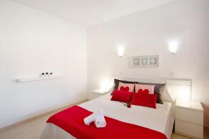 a bedroom with a large bed with red pillows at Paraiso Playa Taurito in Taurito +25 photos