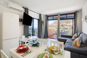 a kitchen and living room with a table and a couch at Paraiso Playa Taurito in Taurito