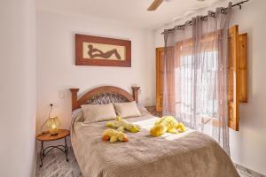 two stuffed animals are sitting on a bed at Casa Rural Martemma in Zuheros +37 photos