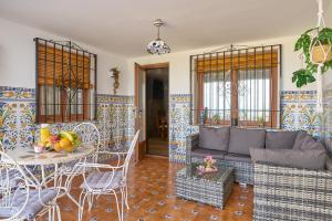 a living room with a couch and a table and chairs at Casa Rural Martemma in Zuheros