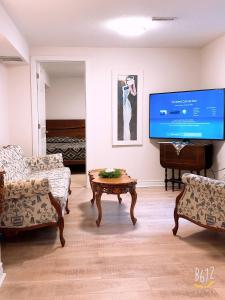 a living room with a tv and a table at Cozy 2bedroom Basement unit in Toronto