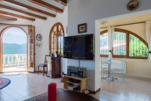 a living room with a flat screen tv and a table at Casa Terra de Chispa by Easy Brava in Calonge