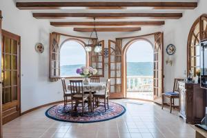 a dining room with a table and chairs and windows at Casa Terra de Chispa by Easy Brava in Calonge