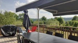 a table and chairs with an umbrella on a deck at Gite La Grange De Loey in Méallet +12 photos
