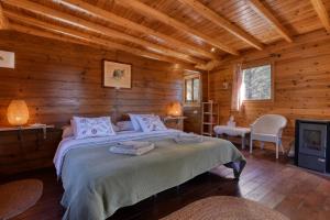 a bedroom with a bed in a log cabin at Awa Natura in Aigues +64 photos