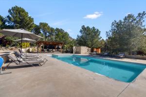 a swimming pool with chairs and an umbrella at Awa Natura in Aigues