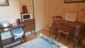 a living room with a table and a desk with a microwave at Villa Eugénie in La Bourboule +11 photos