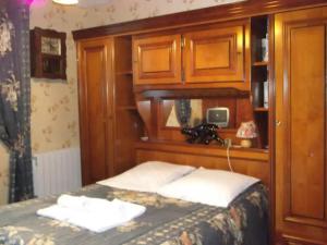 a bedroom with a bed with a wooden head board at Villa Eugénie in La Bourboule