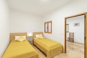 two beds in a room with a mirror at Casa Ñico in Artenara