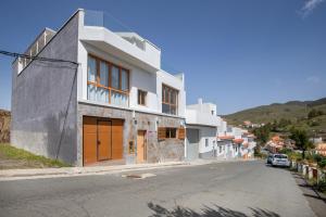 an empty street with a white building on a hill at Casa Ñico in Artenara