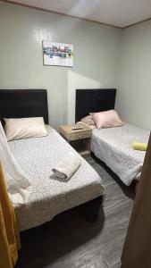 a room with two beds and a table with a bedskirts at Cabañas Simón y kiara in Los Vilos