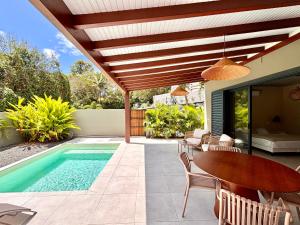 a patio with a table and a swimming pool at CASA M Peaceful haven with pool in Îlet à Christophe