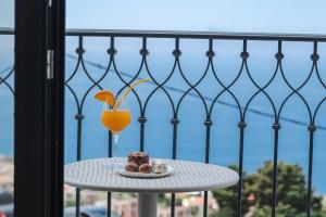a table with a piece of cake and a glass of orange juice at Boutique Villa Levante in Blizikuće