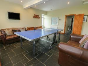 a ping pong table in a living room with couches at Chapel House in Llantrisant