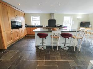 a kitchen with a island with bar stools at Chapel House in Llantrisant