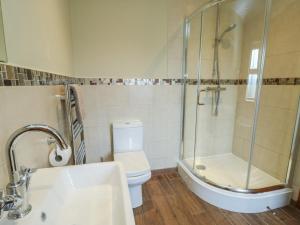 a bathroom with a shower and a toilet and a sink at Chapel House in Llantrisant +23 photos
