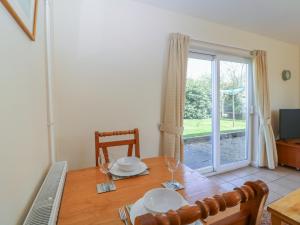 a dining room with a table and a window at The Turbles - Wagtail in Castlemorton