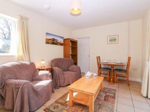 a living room with a couch and chairs and a table at The Turbles - Wagtail in Castlemorton