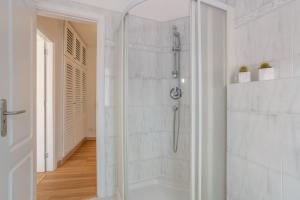a white bathroom with a shower with a glass door at Hiding Place Apartamento Mocan in Los Realejos +17 photos