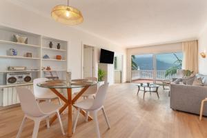 a living room with a glass table and white chairs at Hiding Place Apartamento Mocan in Los Realejos