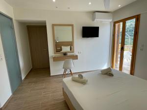 a bedroom with a bed and a desk and a mirror at Lissos Rooms Sougia in Sougia