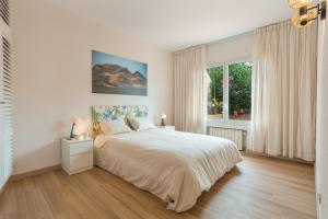 a white bedroom with a large bed and a window at Hiding Place Apartamento Mocan in Los Realejos