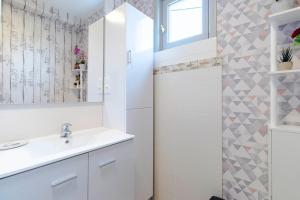 a white bathroom with a sink and a shower at Gîte Lavand Cottage À Brantôme in Brantôme +22 photos