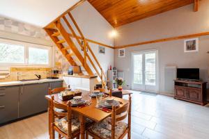 a kitchen with a wooden table and chairs in a room at Gîte Lavand Cottage À Brantôme in Brantôme