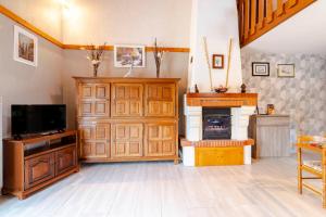 a living room with a television and a fireplace at Gîte Lavand Cottage À Brantôme in Brantôme