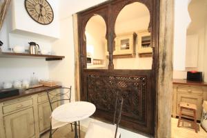 a kitchen with a large wooden door with a clock on the wall at Aux Bords du Temps in Zonza