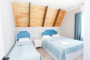 two beds in a room with blue and white at Forest Luxe A-Frame Villa in Quba +10 photos