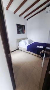 a bedroom with a bed in a white room at Alojamiento Santa Fe de Antioquia in Santa Fe de Antioquia