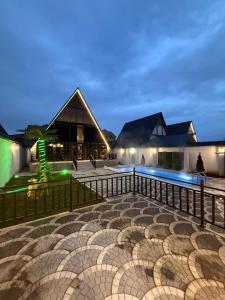 a villa with a swimming pool at night at Forest Luxe A-Frame Villa in Quba