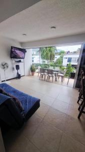 a living room with a couch and a television and a patio at Alojamiento Santa Fe de Antioquia in Santa Fe de Antioquia