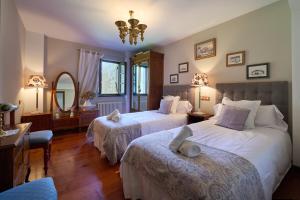 a hotel room with two beds and a mirror at The Basque Experience by Fidalsa in Ochandiano