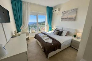 a bedroom with a large bed and a large window at EDEM free parking, sea view & pool in Kunje +46 photos