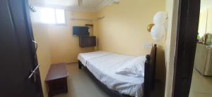 a small room with a bed and a window at MSN-Gate1Temple in Srikalahasti