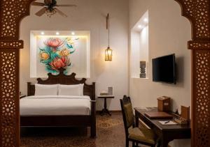 a hotel room with a bed and a desk with a desk at Villa Merida Luxury Mansion - Adults Only Boutique Hotel in Mérida