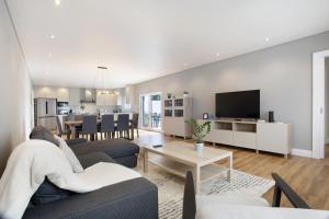 a living room with a couch and a dining room at Casa D'Avó - Family Coastal Escape in Casa Nova