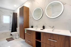 a bathroom with a sink and two mirrors on the wall at Casa D'Avó - Family Coastal Escape in Casa Nova +19 photos
