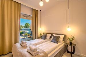 a bedroom with a large bed and a window at Amber Seaside Apartment - Luxury Apartment with Balcony and Parking in Gdansk in Gdańsk