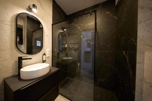 a black bathroom with a sink and a mirror at Amber Seaside Apartment - Luxury Apartment with Balcony and Parking in Gdansk in Gdańsk +13 photos