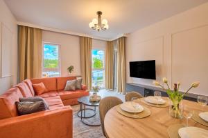 a living room with a couch and a table at Amber Seaside Apartment - Luxury Apartment with Balcony and Parking in Gdansk in Gdańsk