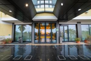 an empty lobby of a building with glass doors at Hotel Tiffany Milano in Trezzano sul Naviglio