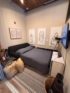 a bedroom with a bed and drawings on the wall at Bradshaw Lofts The Brixton King Suite in Stratford