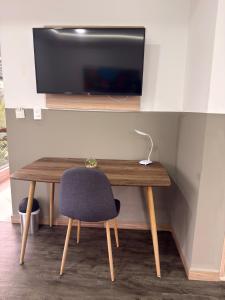 a wooden table with a chair and a television at Hotel Valle de San Nicolas in Rionegro