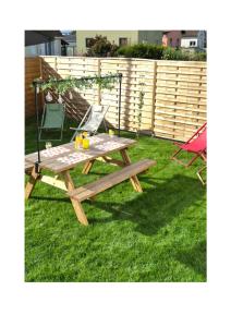 a picnic table and a chair on the grass at chez mamy in Reguisheim