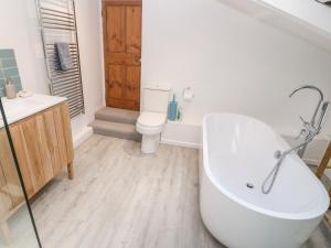 a bathroom with a bath tub and a toilet at Widgeons Keel in Falmouth +23 photos