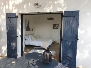 a bedroom with an open door with a bed at Chambres D'hôtes - Noirmoutier in LʼÉpine