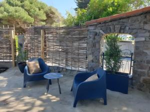 two blue chairs and a table on a patio at Chambres D'hôtes - Noirmoutier in LʼÉpine